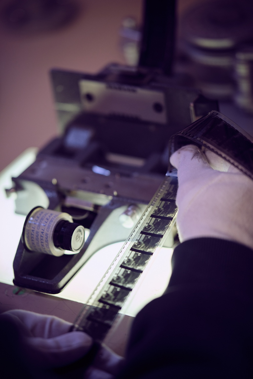 Projectionniste entrain d'analyser un bout de film 